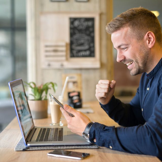 happy-freelancer-with-tablet-laptop-computer-coffee-shop